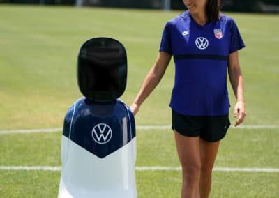 Volkswagen's CHAMP rolling next to USWNT's star forward Alex Morgan on a soccer field