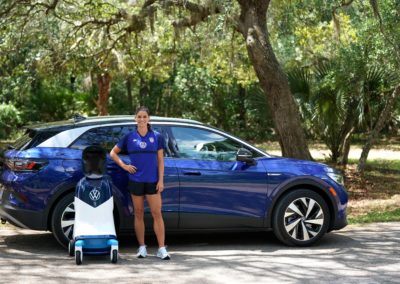 Volkswagen's CHAMP standing next to USWNT's star forward Alex Morgan in front of the all-new Volkswagen ID.4 electric vehicle
