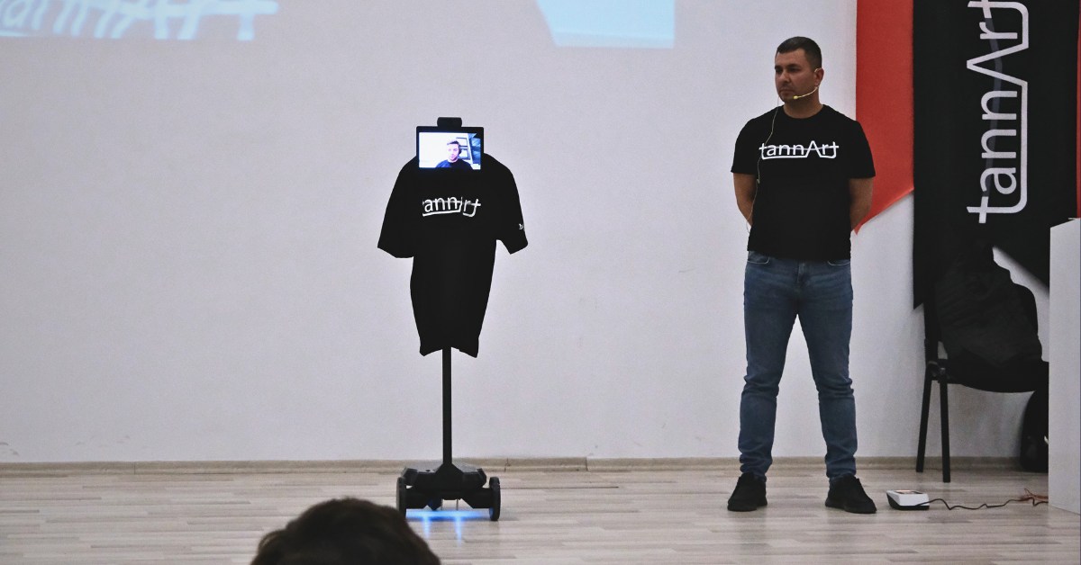 Volkan Yilmaz uses a telepresence robot to deliver remarks at a conference.